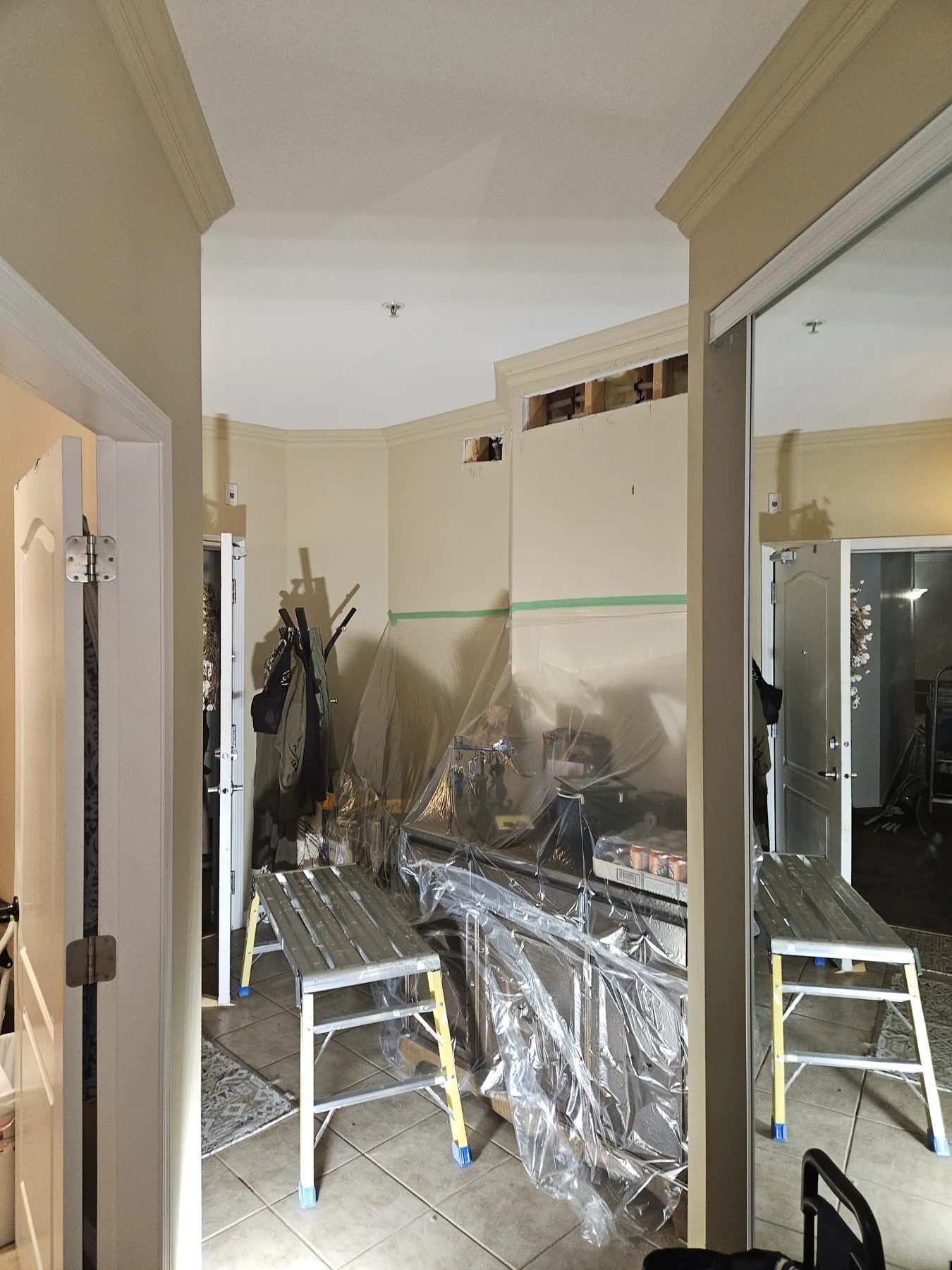 Protective sheeting and staging prepared around an occupied suite work area